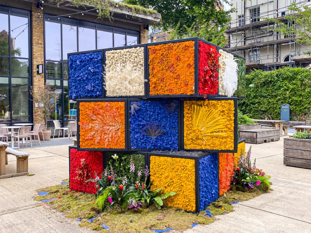 A life size rubiks cube made from flowers