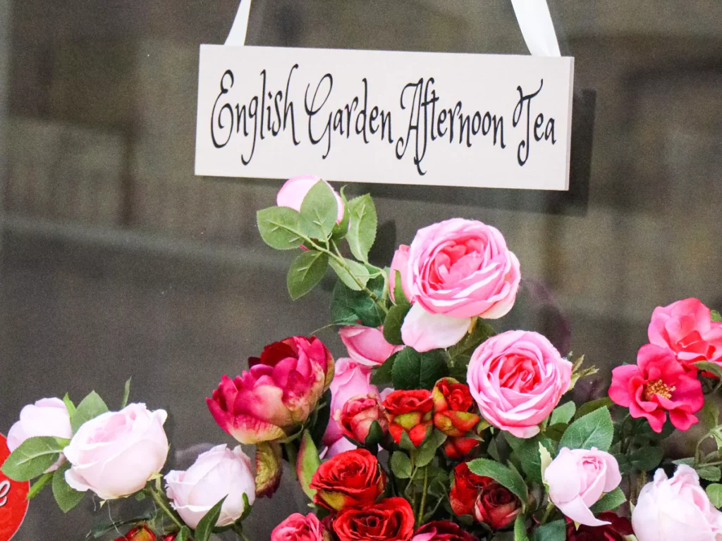 English Garden Afternoon Tea sign with a bunch of roses below