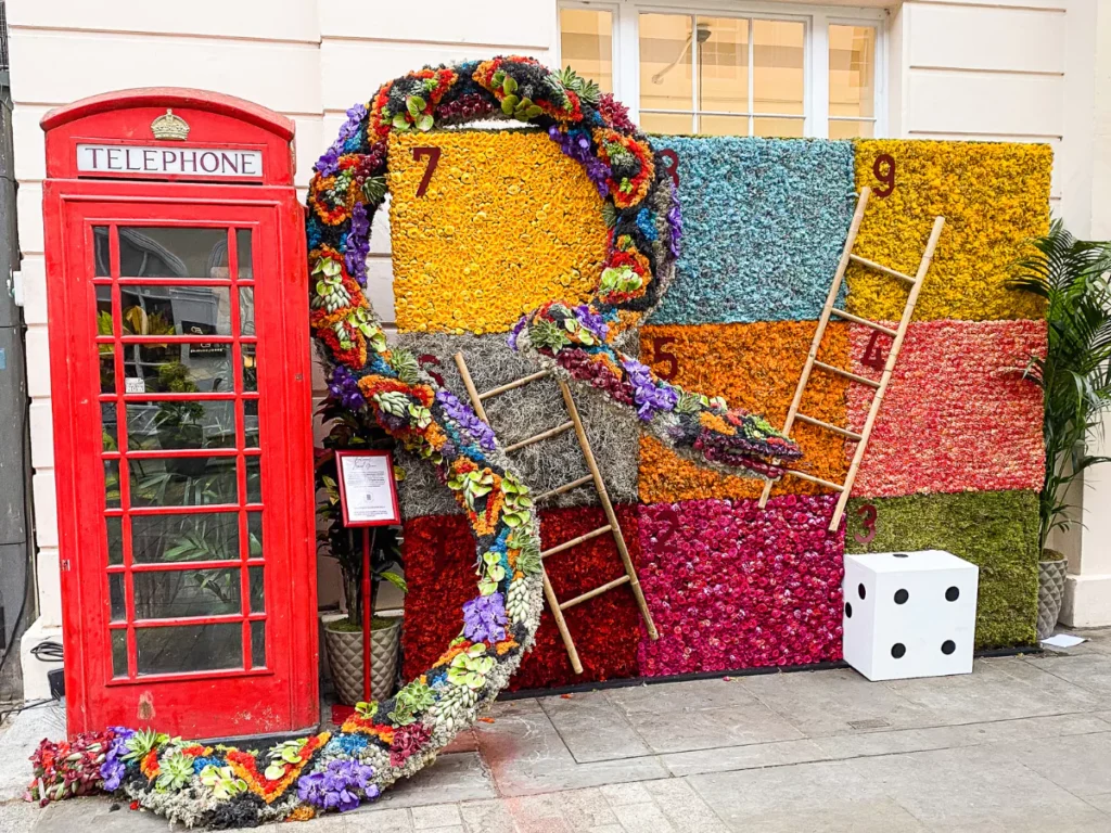 a life size snakes and ladders playing board made of flowers