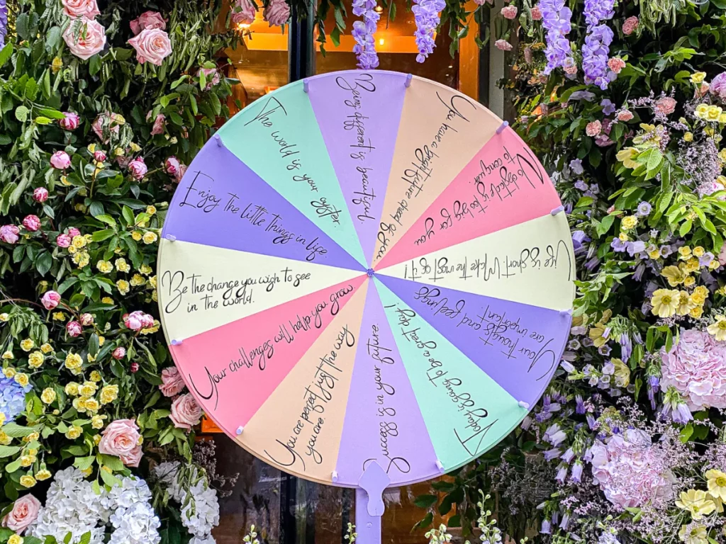 a pastel spinning wheel framed by purple hanging flowers