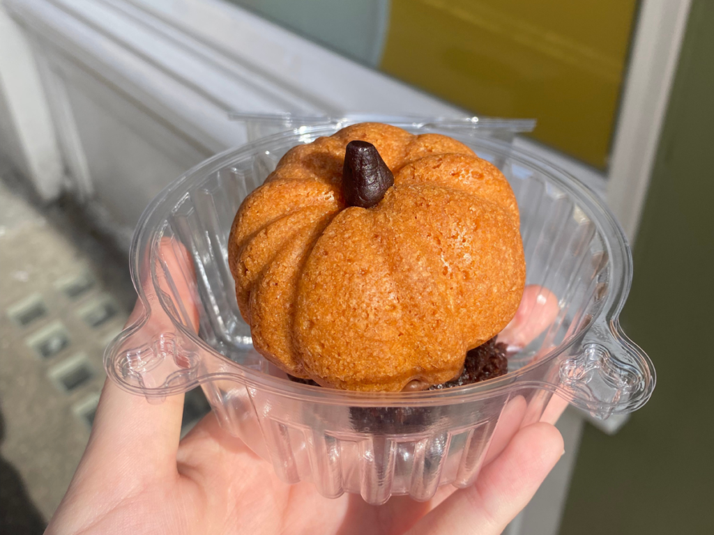 an orange spiced cookie in the shape of a small pumpkin sat on top of a brownie
