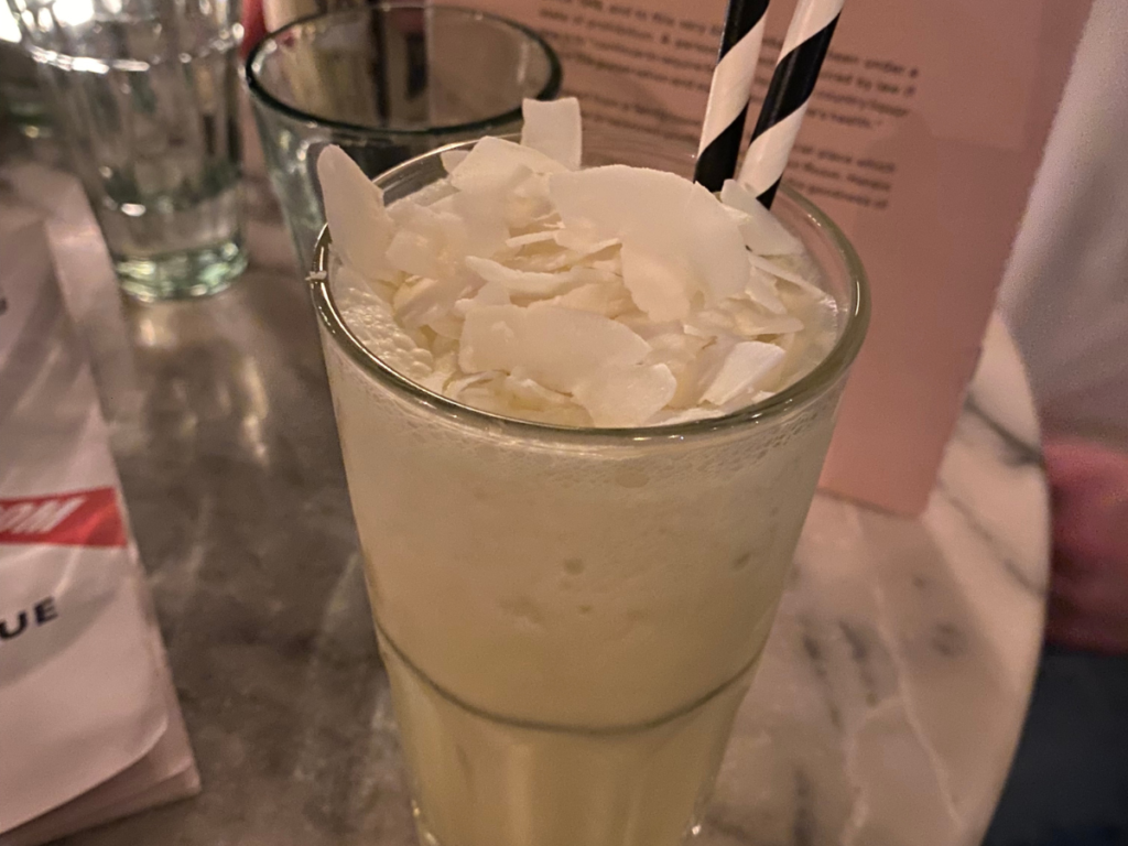 a delicious alcohol-free pina colada with coconut flakes on top