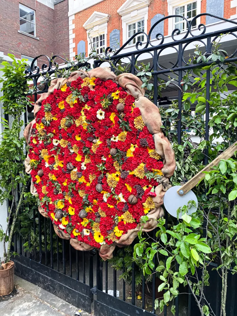 Pizza Express in Chelsea show off a large pizza made from red and yellow flowers for Chelsea in Bloom 2024