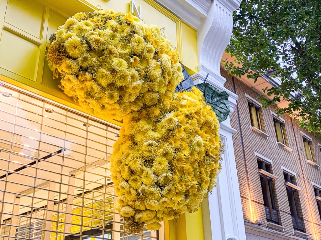Two big lemons made of yellow flowers on the top corner of Trinny London's shop facade