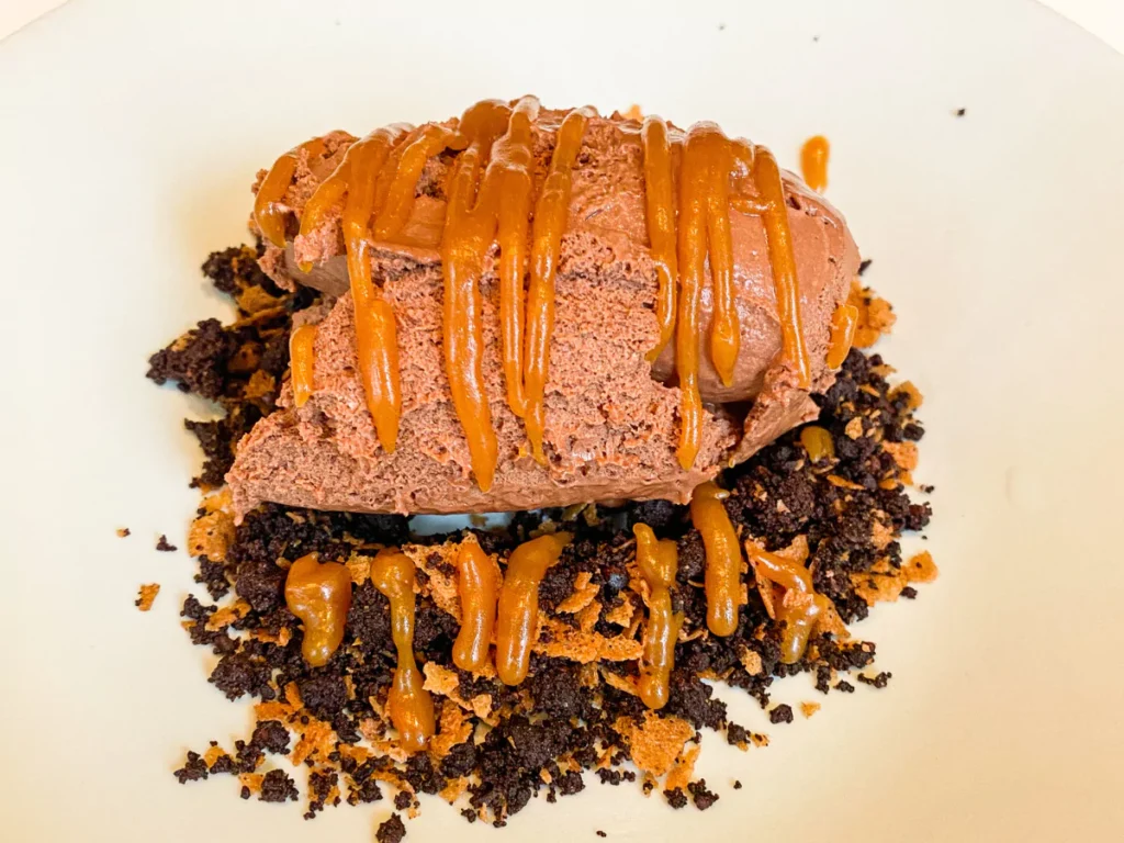 chocolate mousse on chocolate biscuit crumbs with salted caramel sauce over the top