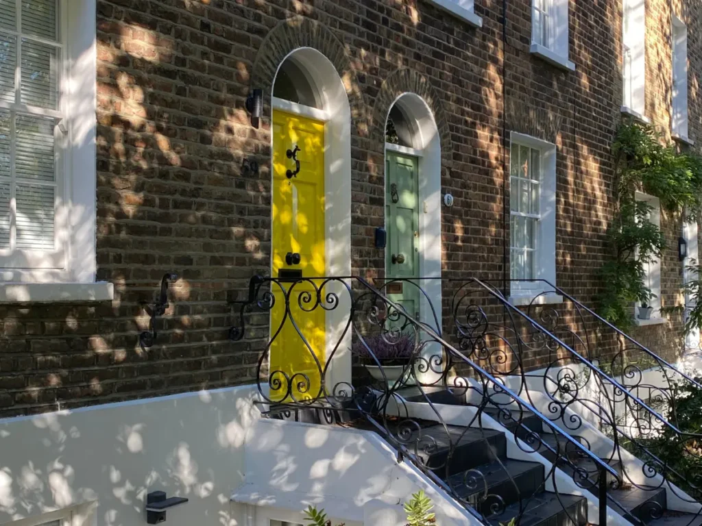 A yellow and green door up iron stairs