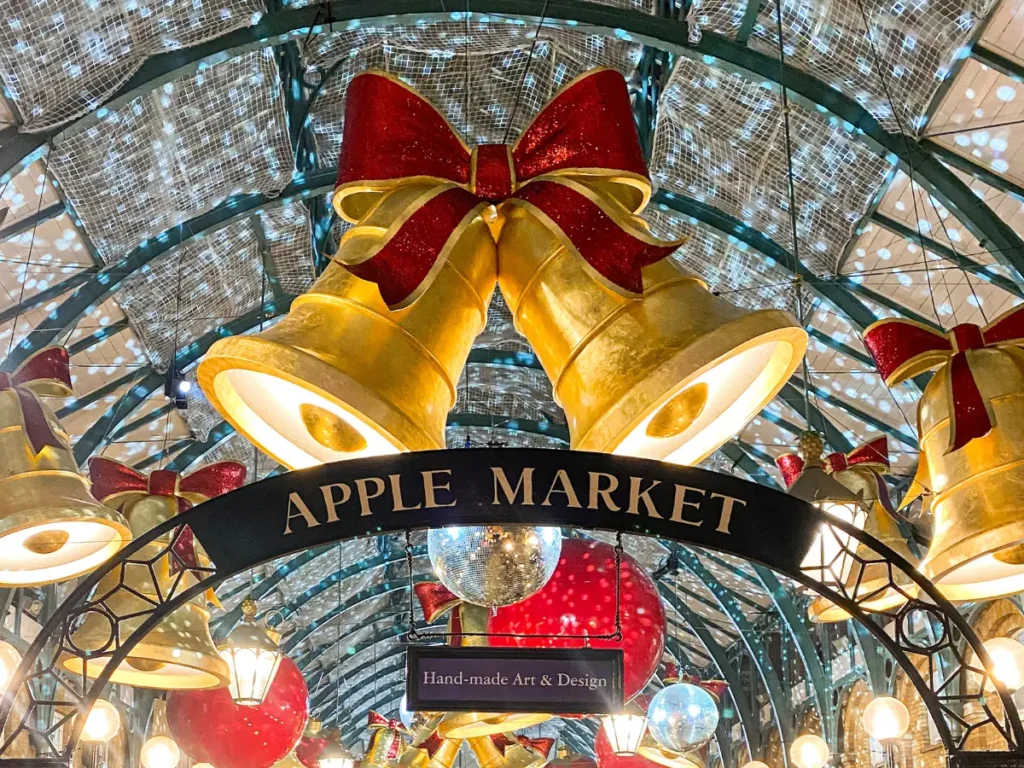 Covent Garden's large Christmas bells with red bows above the the apple market sign